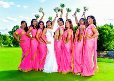 Indian Bride and Bridesmaids posing on Springfield Country Club's golf course with their hands above their heads holding flowers