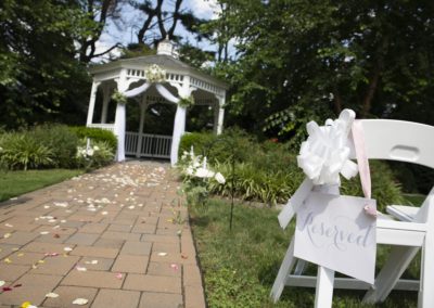 Springfield Country Club Gazebo with path leading up to it and a folding chair with Reserved sign for an outdoor wedding.