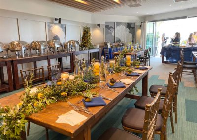 Wooden tables with blue and yellow decorations in La Vista room with open patio in background.