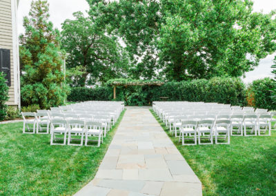 Outdoor wedding ceremony set up with white lawn chairs at the Ceremony Garden.