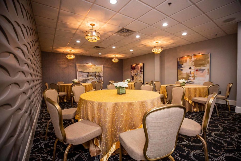 The Club Room with round tables and gold tablecloths.