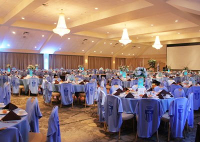 Corporate Event setup with blue theme and T-shirts for all the attendees draped on the chairs.