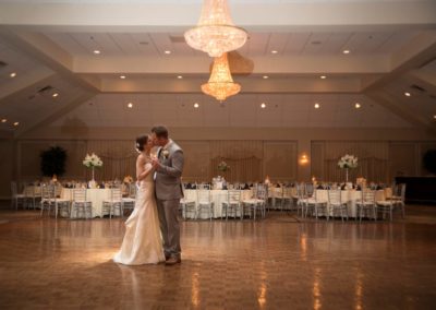 Couple on grand ballroom floor dancing and kissing.