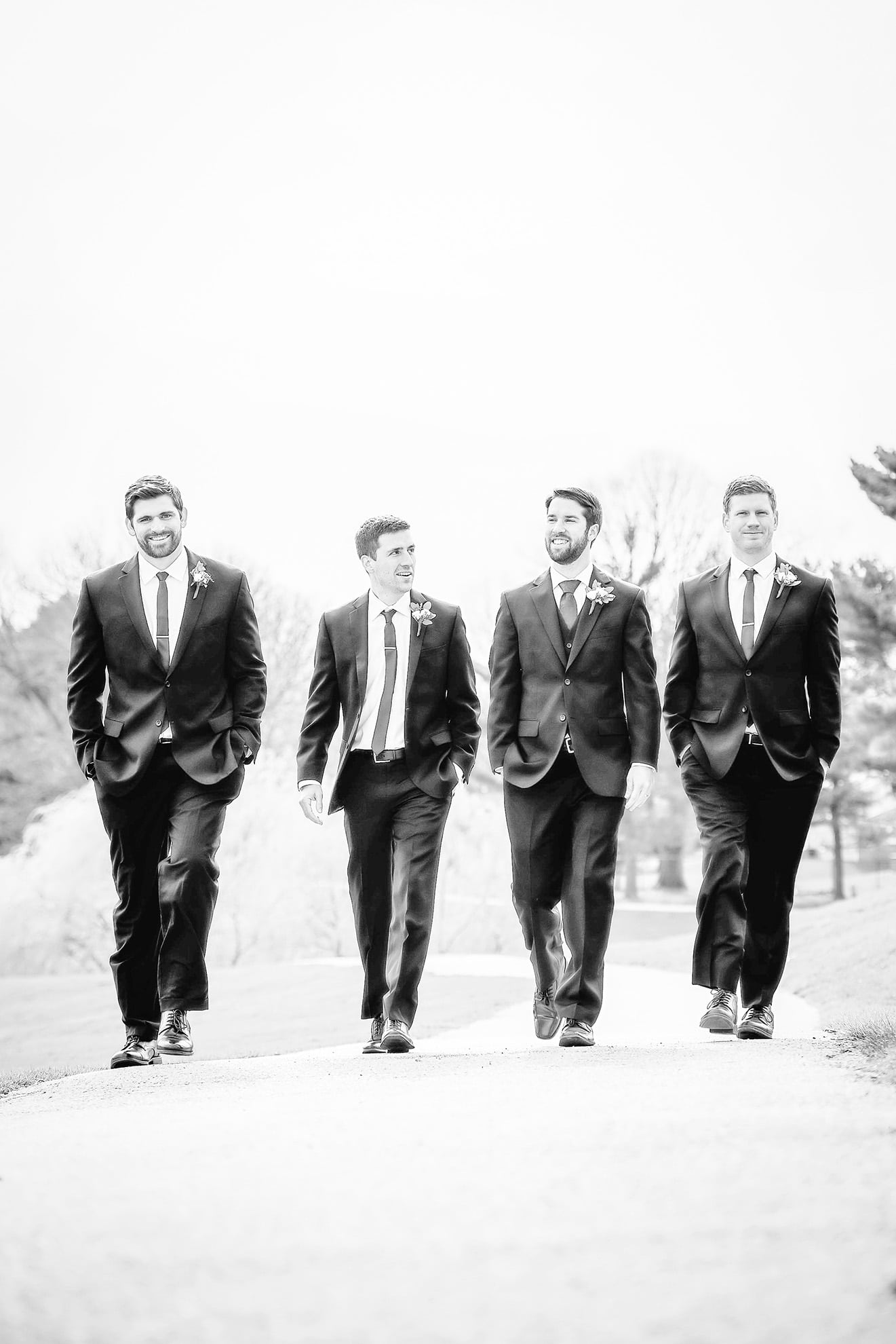 Groomsmen walking down a golf course path with the groom. Photo by DMP Family Life