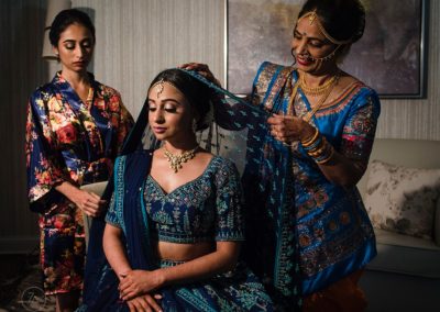 An Indian Bride getting ready with her bridesmaid and mother