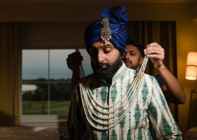 Indian Groom being dressed in traditional garb