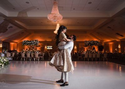 A Groom lifting his Bride into the air on the ballroom floor