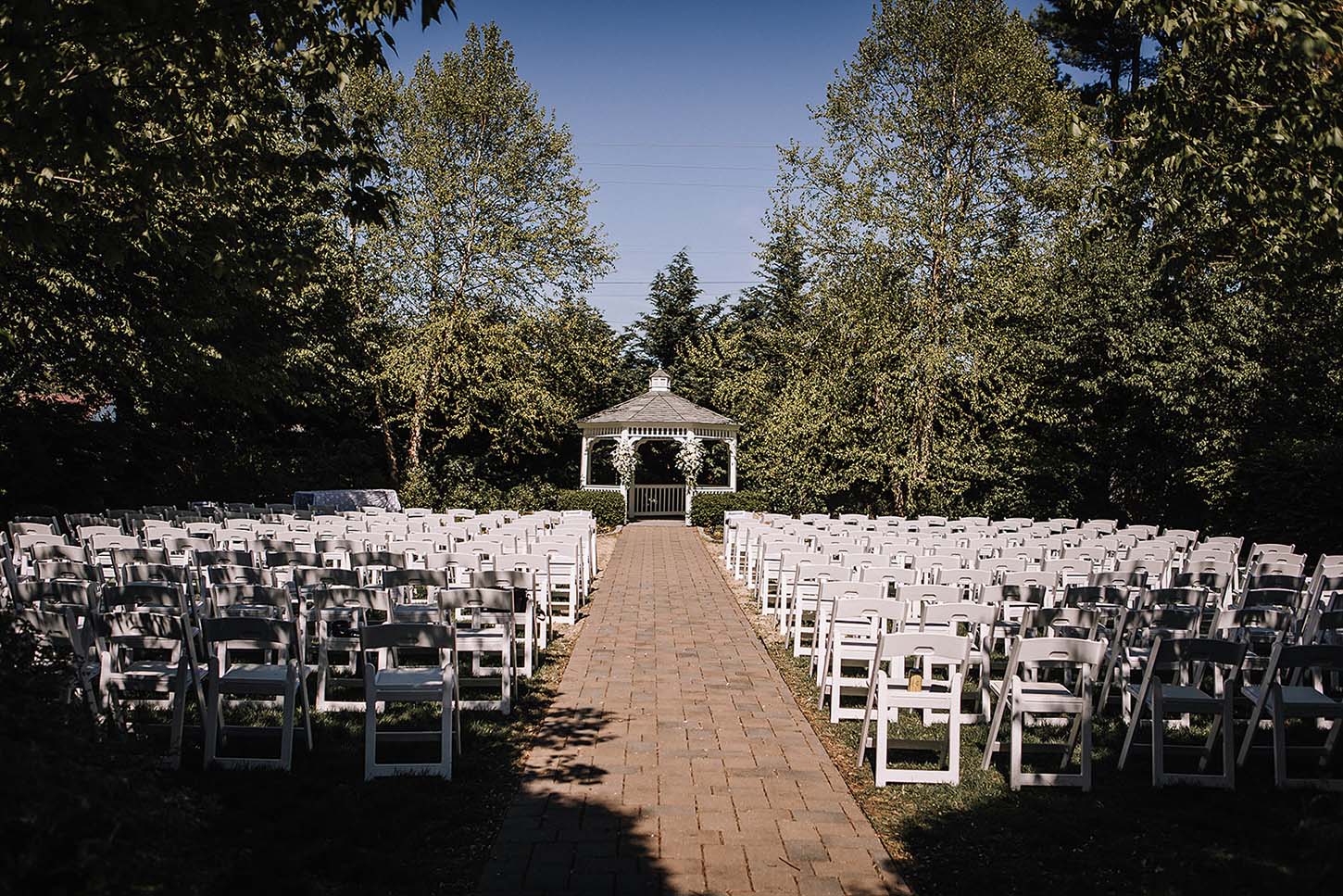 Looking down the main aisle of an outdoor wedding towards the wedding altar before the guests arrive. Photo by Kristy Hoadley Photography.
