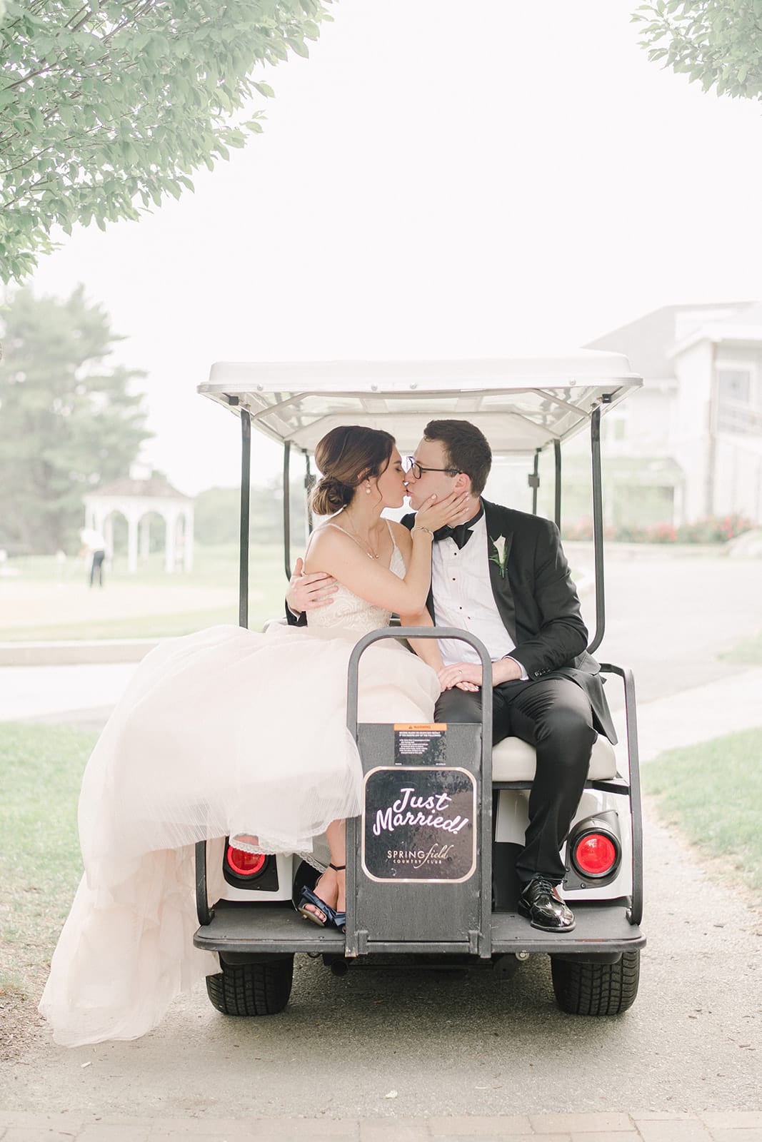 Bride and Groom kissing in the back of a golf cart. Photo by Morgan Taylor Artistry
