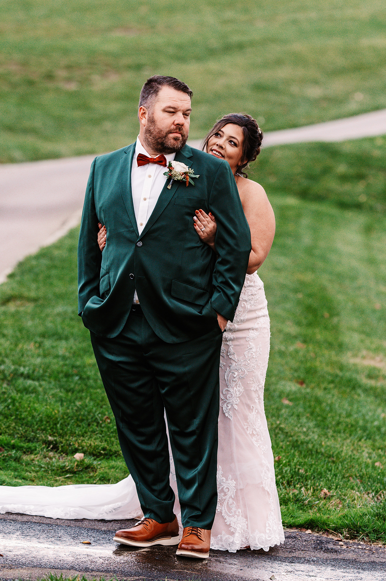 Groom in green suit with bride standing behind him. Photo by Olga Hinchman Photography