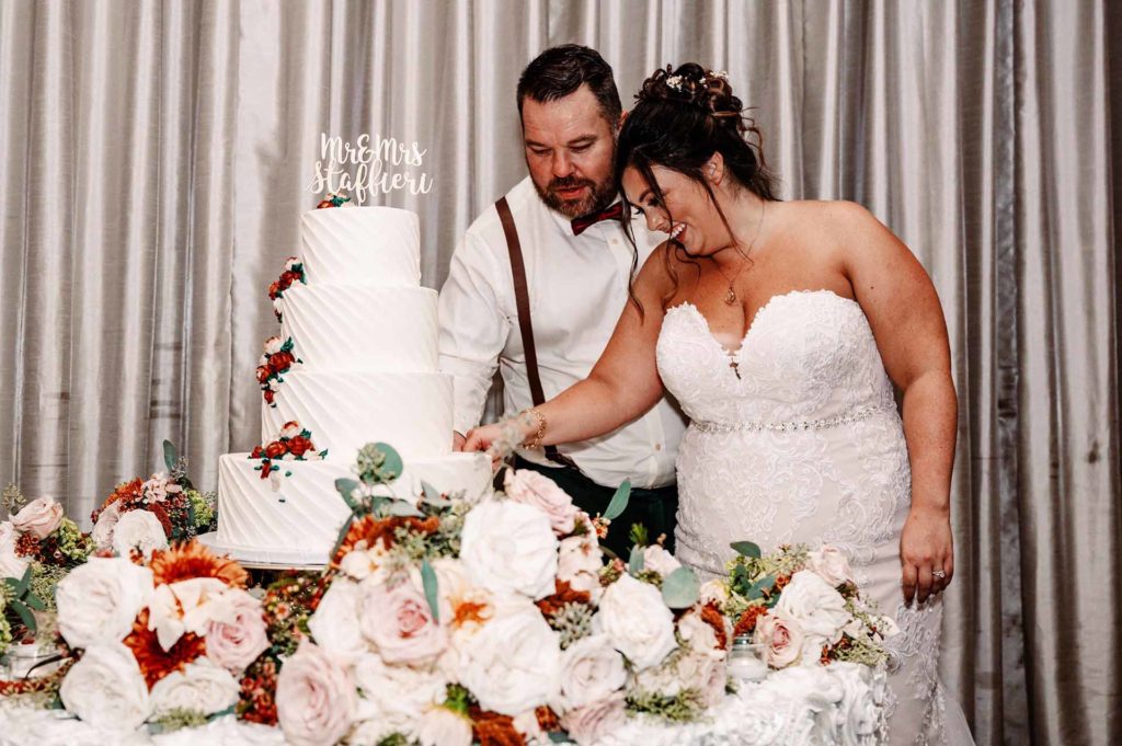 Bride and Groom cutting wedding cake. Photographed by: Olga Hinchman Photography