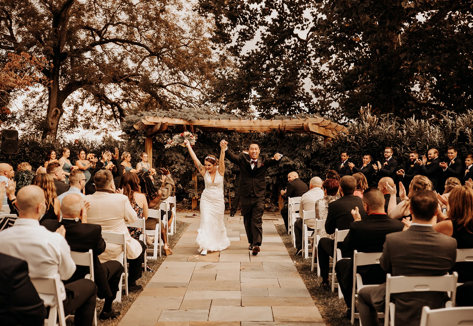 Just married couple walking down aisle after an outdoor ceremony.