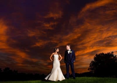 Rachel and Joe on golf course with dramatic orange sky in the background.