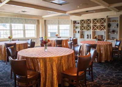 Reserve Room at Springfield Country Club decorated in tans and browns with round tables with rose center pieces.