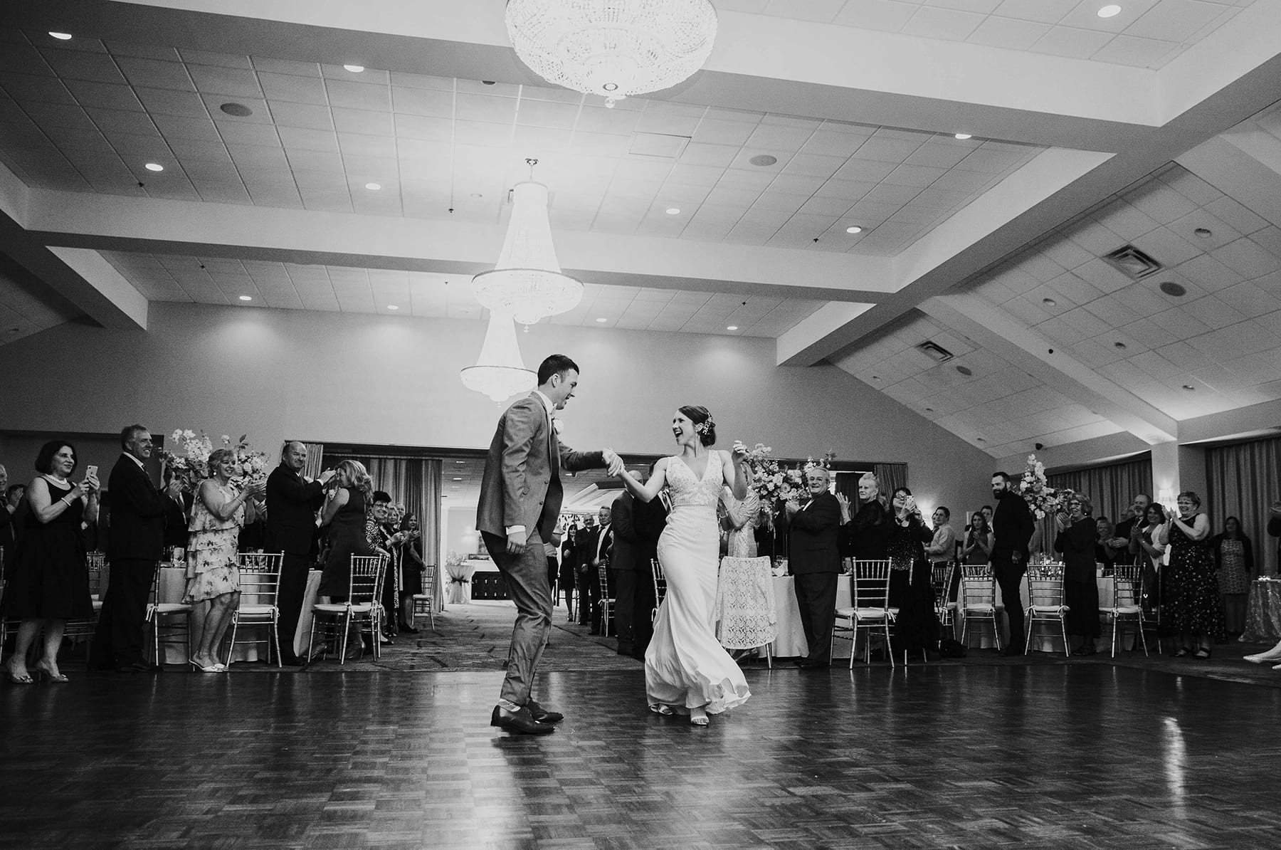 Black and white photo of wedding couple dancing to their wedding playlist.